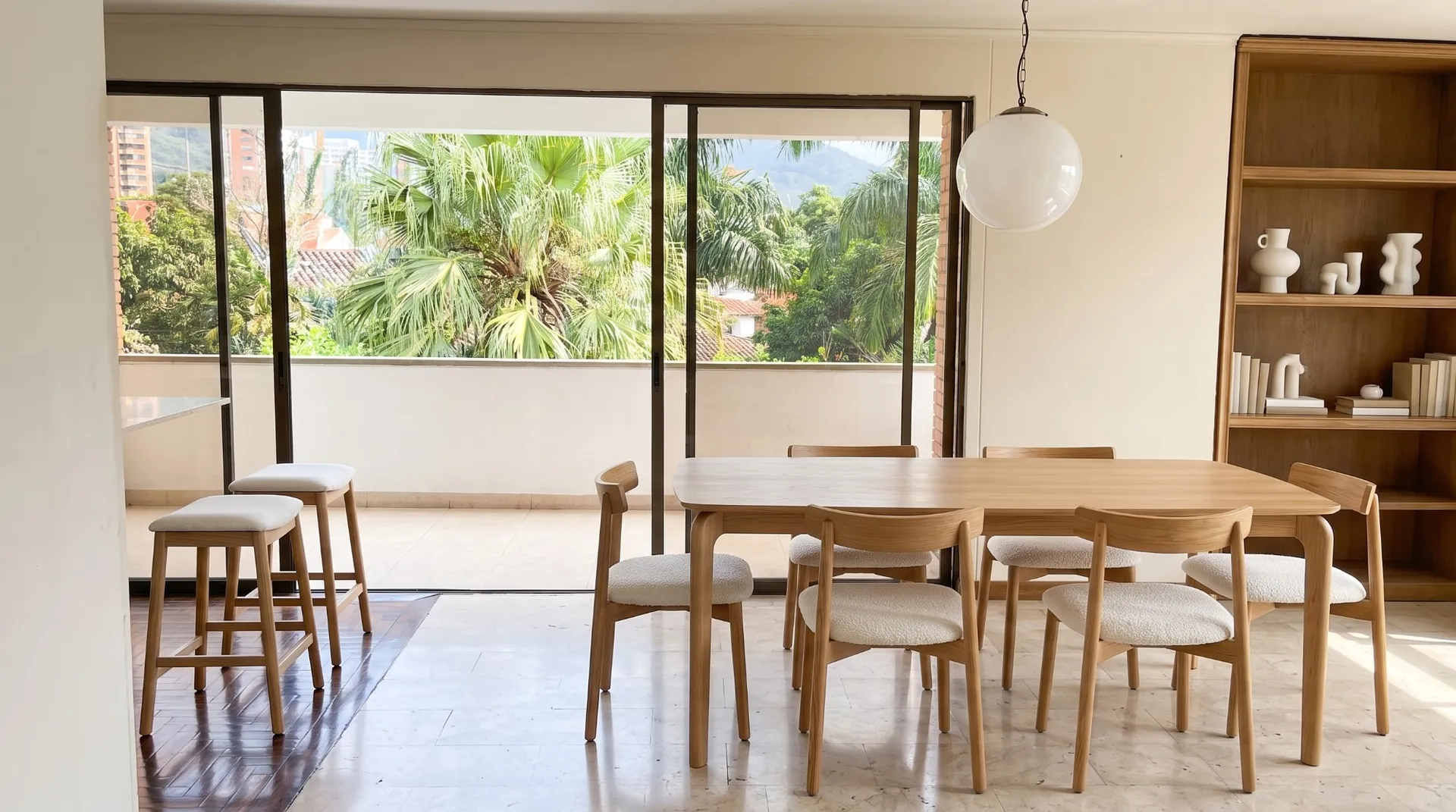 El mismo comedor con amoblamiento virtual: mesa de madera clara con sillas y dos butacos.