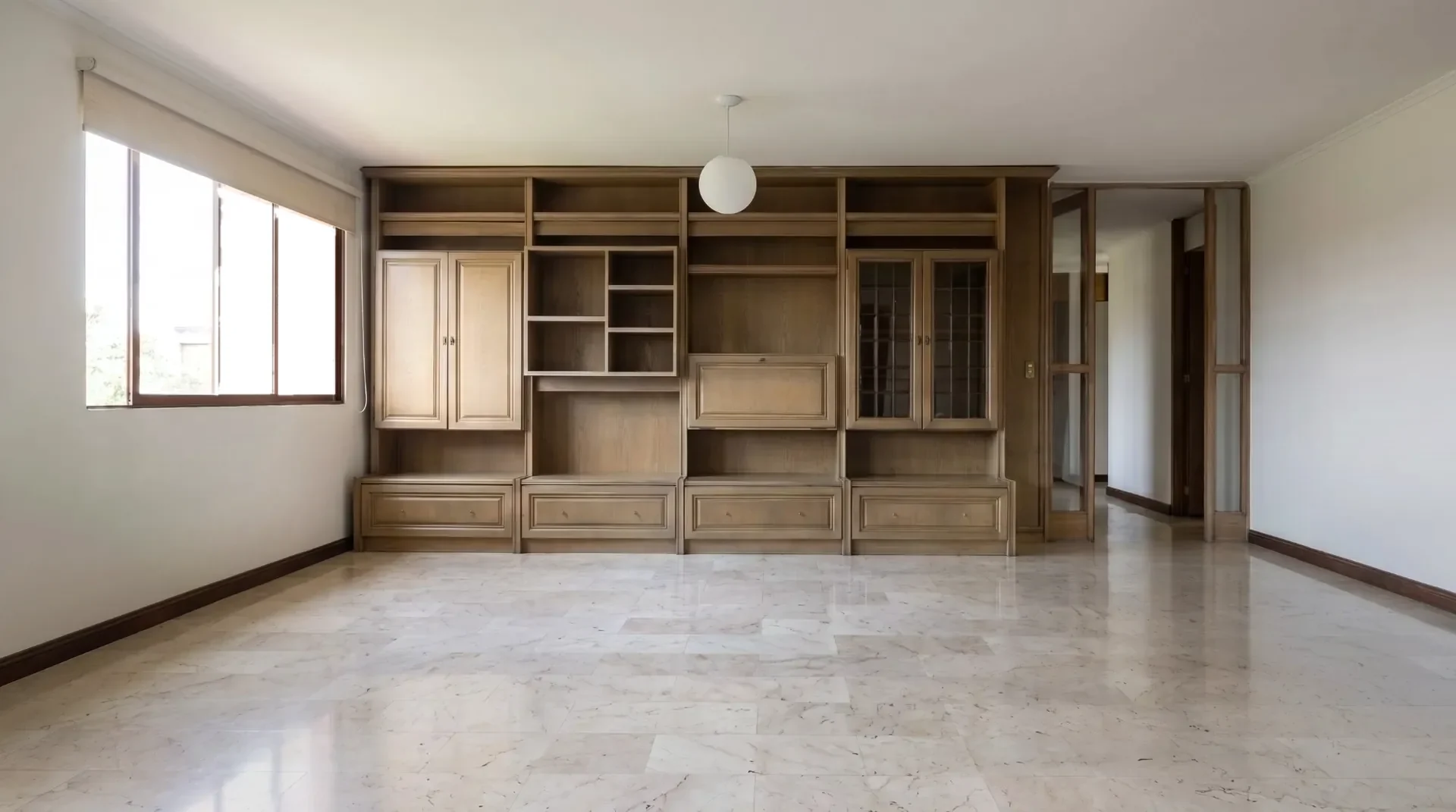 Sala vacía con una biblioteca de madera a lo largo de la pared.